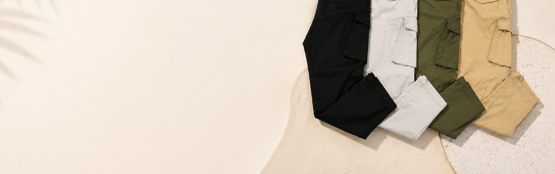 Folded cargo pants in black, white, olive, and tan
