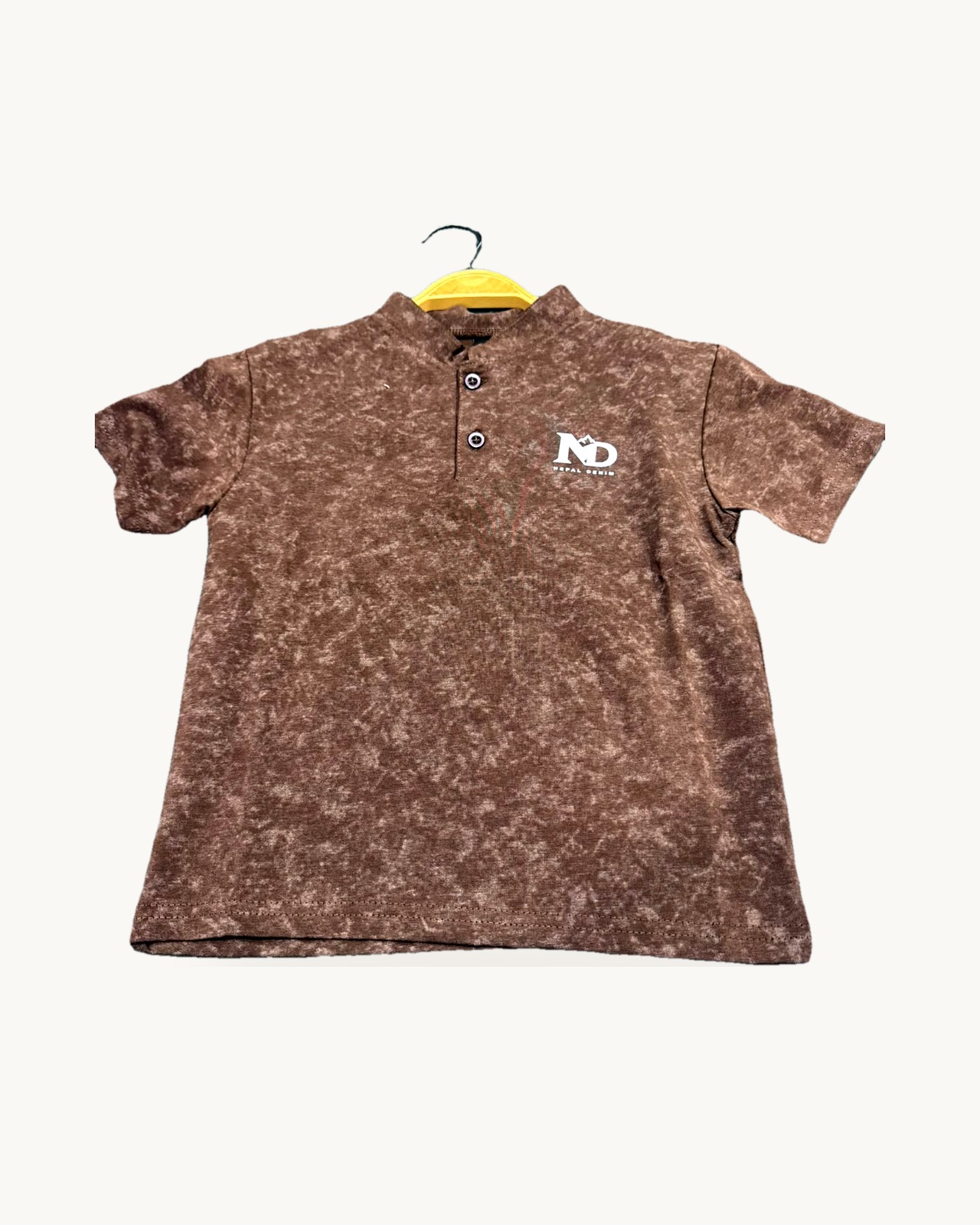 Tan button t-shirt on a hanger
